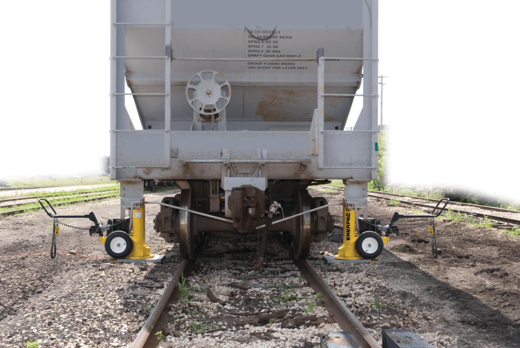 wheeled jacks lifting a railcar
