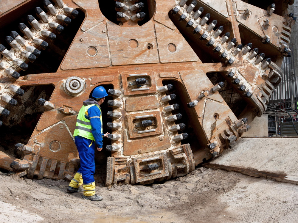 man inspecting tunnel boring machine